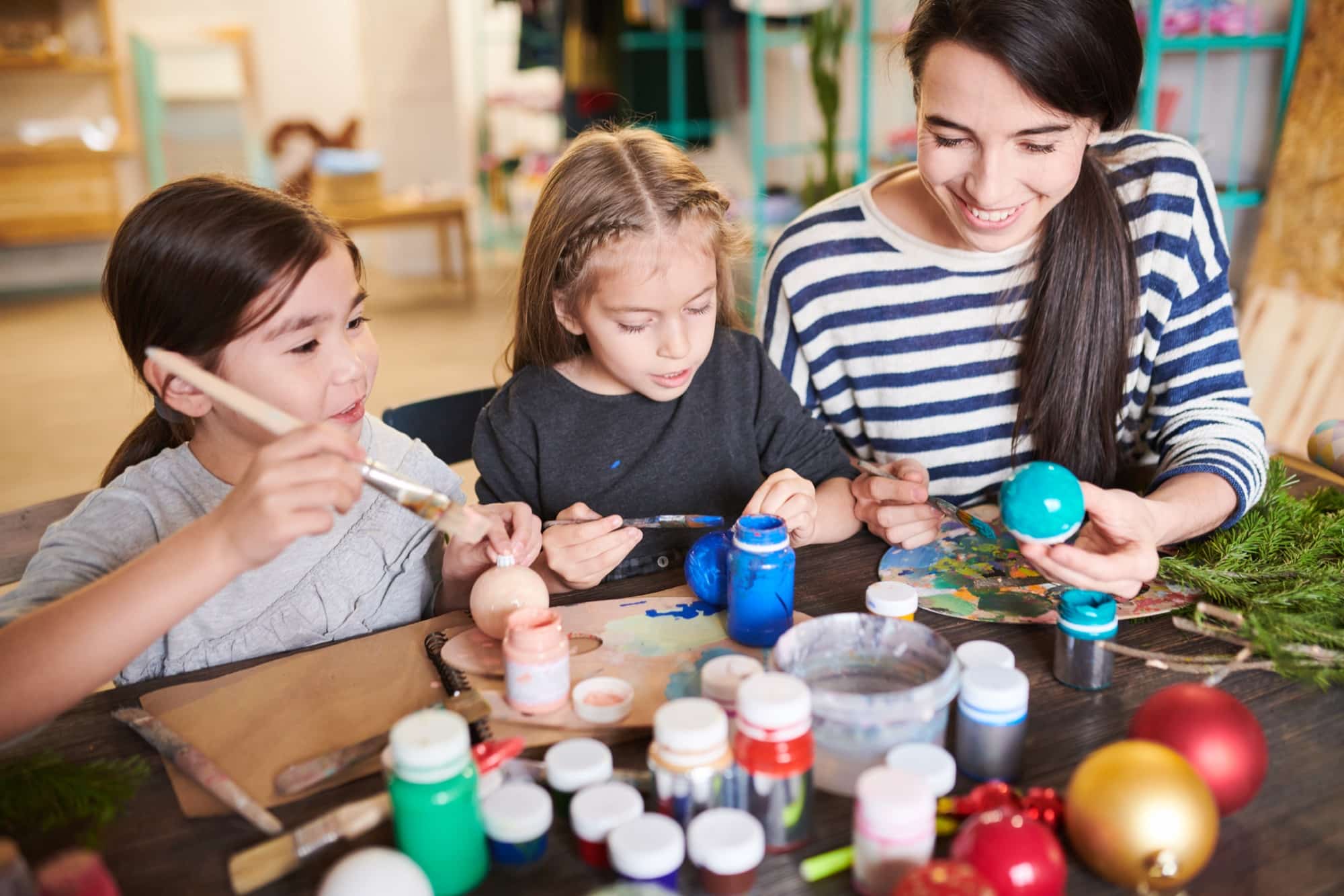 Enfants et adulte peignent des décorations en atelier