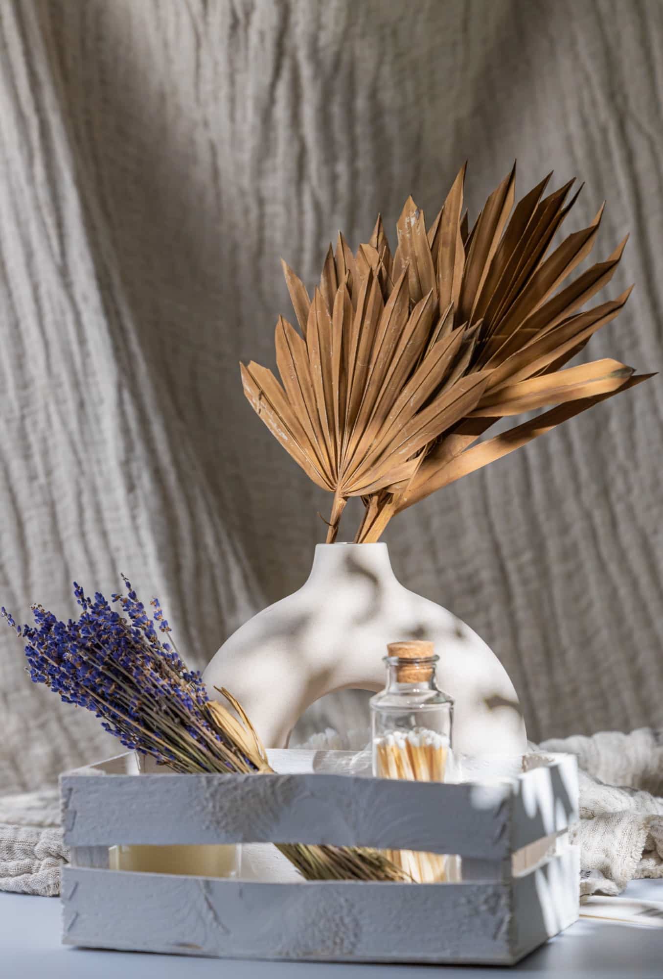 Vase en céramique, palme séchée et lavande, réunis dans une caisse en bois