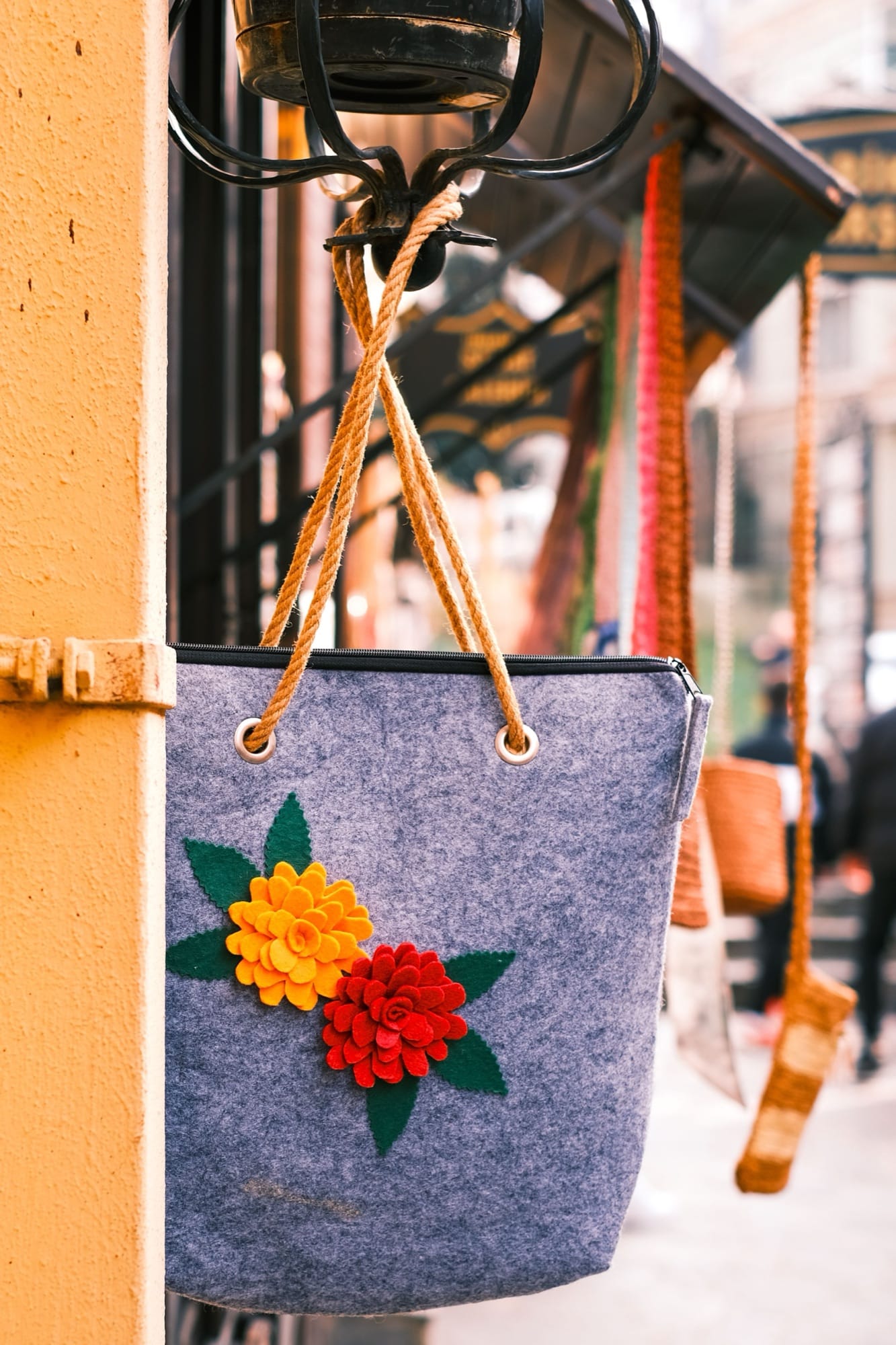 Un sac en feutre fleuri, accroché en devanture