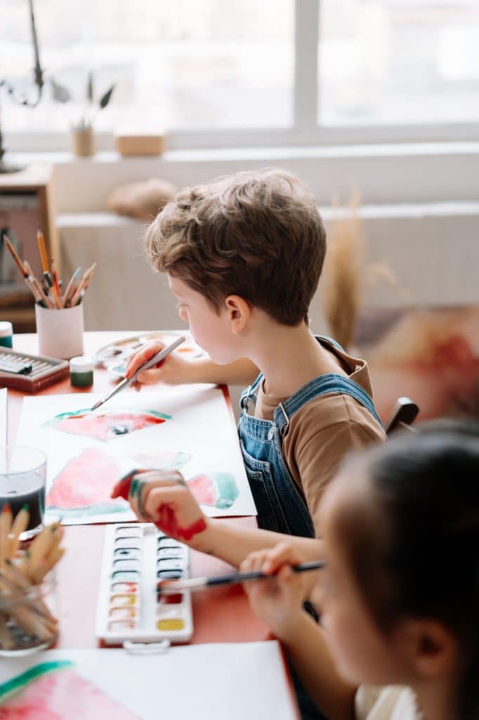 Un enfant assemble sa création à la table d'atelier