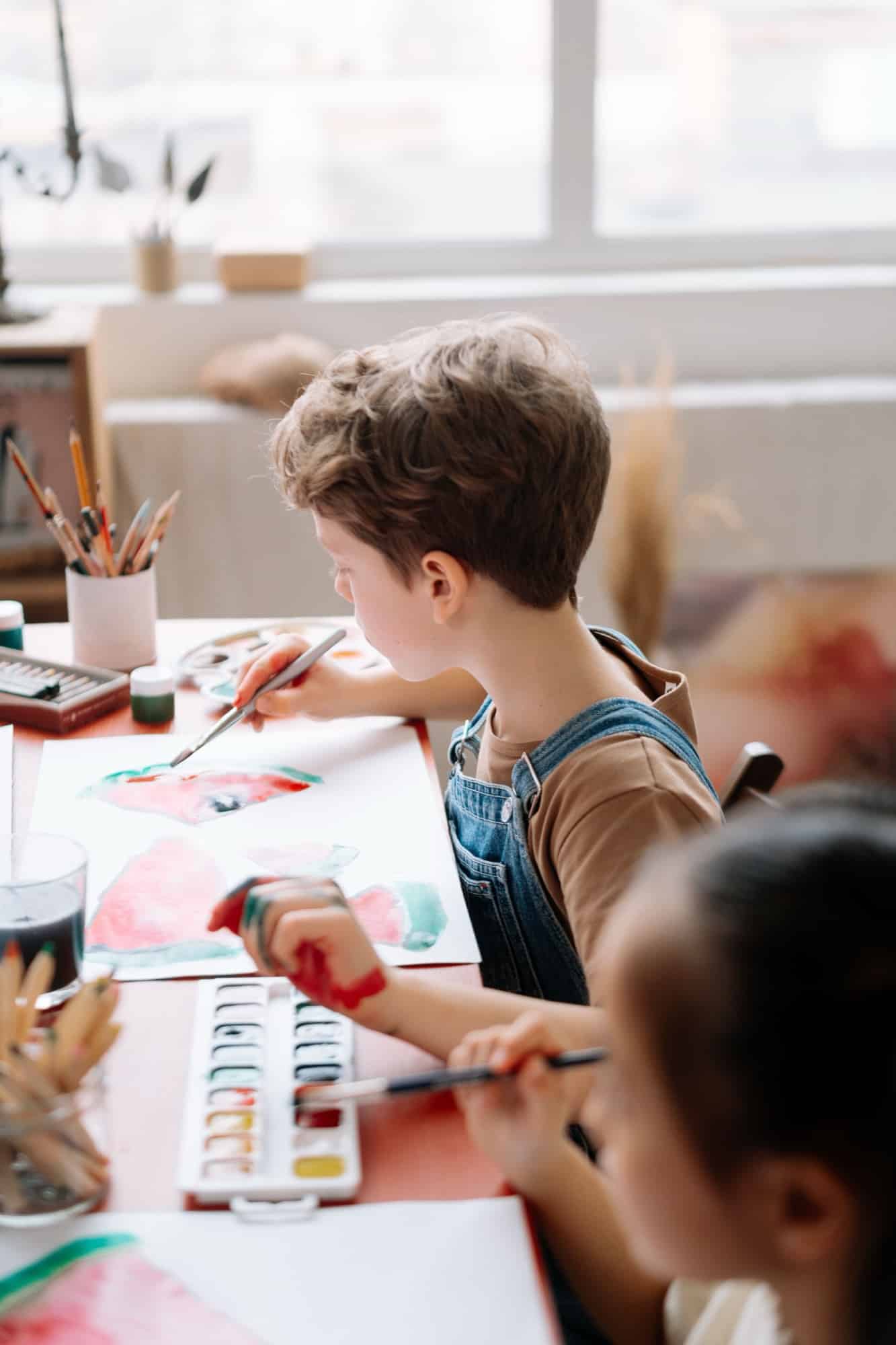 Un enfant assemble sa création à la table d'atelier